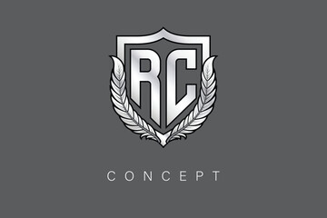 RC Creative Initial Letter Logo with Shield and Laurel Wreath Silver Metallic Branding Emblem on Gray Background.