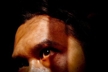 Close-Up of Man's Face with Focused Eyes in Low Light