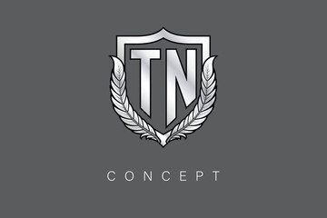 TN Creative Initial Letter Logo with Shield and Laurel Wreath Silver Metallic Branding Emblem on Gray Background.