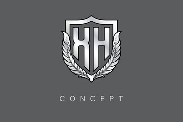XH Creative Initial Letter Logo with Shield and Laurel Wreath Silver Metallic Branding Emblem on Gray Background.