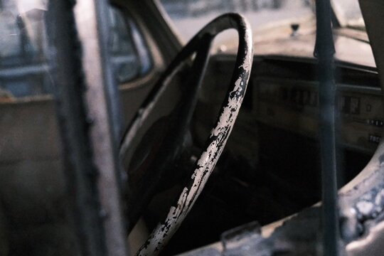 Fototapeta Atmospheric close-up of a peeling steering wheel inside a forgotten, dusty vintage car.