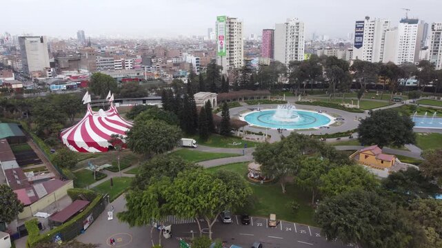 Red and white circus tent near a fountain in Magic Water Circuit,Reserve Park lima, Peru