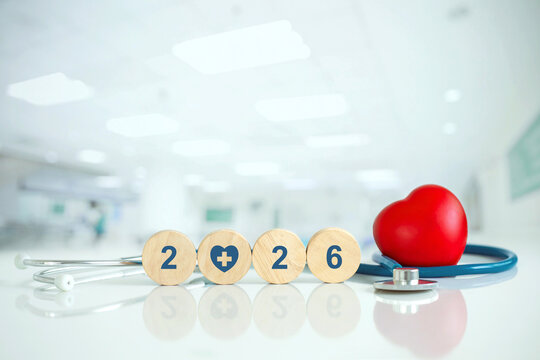 Stethoscope and red heart beside wooden rounds showing 2026 in a bright hospital, symbolizing New Year health goals, wellness, checkup, medical care, insurance planning, prevention, and lifestyle.