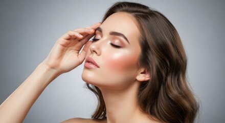 Obraz premium A beautiful woman with closed eyes and a hand on her forehead, showcasing glowing skin