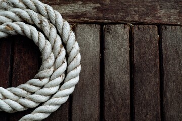 Obraz premium White rope coil on weathered wood