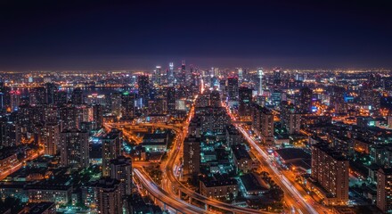 Fototapeta premium Aerial Night Cityscape: Illuminated Skyscrapers, Highways, and Urban Lights.