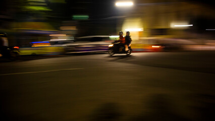 panning photo of motor vehicles on the street at night
