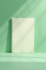 Blank Spiral Notebook on Green Surface with Natural Light Bright and Minimalist