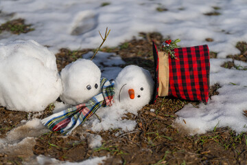 A snowman slowly melting in the sun. End of winter, hello spring. Winter and spring seasons change....