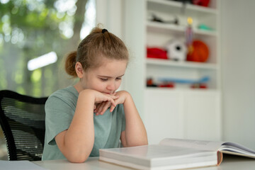 Child reading book at home. Child book studying. Child opening book indoors. Child earning with books. Boy focused on textbook lesson. Clever student reading storybook. Kid studying book at desk.
