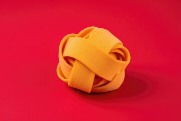 Orange pasta nest on red background