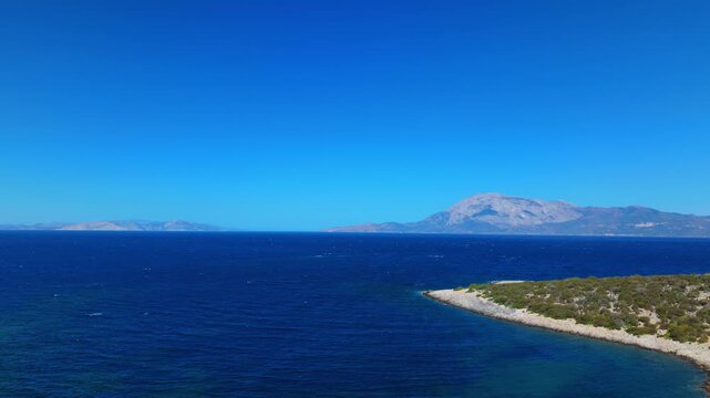 Aerial shot of Samiopoula coastline with the massive Mount Kerkis dominating the background, Samos, Greece