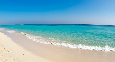 Obraz premium Crystal clear turquoise ocean waves gently lap onto a serene sandy beach under a clear blue sky