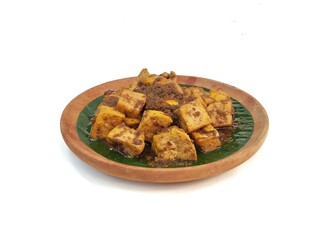 Tahu bumbu kecap or Indonesian food made from tofu with spices and soy sauce on wooden plate isolated on white background, High angle view 