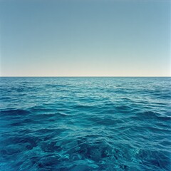 Obraz premium Tranquil ocean scene, clear blue water under a pale sky