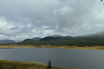 Serene Mountain Landscape with Calm Waters and Dramatic Sky