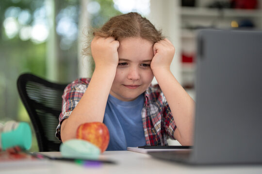 Kid learning at home with laptop and books. Child learn online using laptop at desk. Learning with homework in child room. E-learning on laptop. Kid learning at home. Back to school. - Powered by Adobe