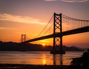 A magnificent cable-stayed bridge stretches across a calm body of water at sunrise, silhouetted against a fiery orange and pink sky.