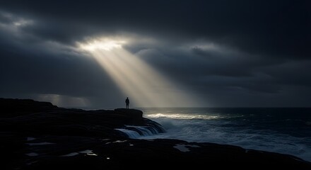 A solitary figure stands on a dark, rocky coastline, illuminated by dramatic sun rays breaking through stormy clouds over a turbulent sea.