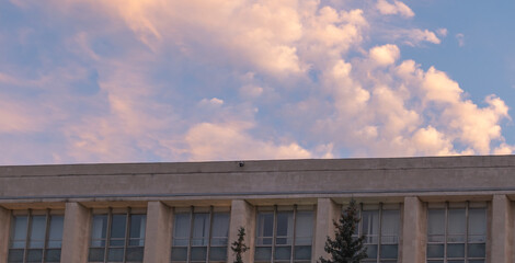 Modern Government Building Facade with Windows under Pink Cloudy Sky at Sunset