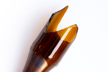 A broken brown glass bottle with sharp jagged edges at the top.