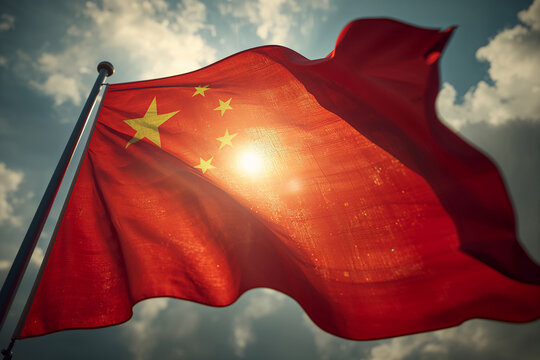China national flag waving in the wind with bright sunlight shining through, featuring red background and golden stars, symbol of unity, strength, pride, and national identity