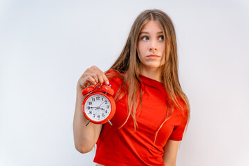 A young beautiful girl holds a Red alarm clock on an isolated background. Time management concept