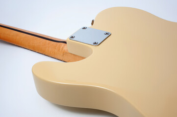 Six-string electric guitar, with a cream-colored wooden body and chrome-plated fittings.