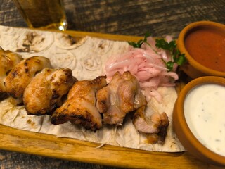 delicious tender chicken shashlik lies on a cutting board on pita bread