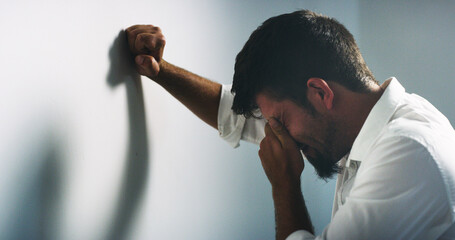 Depression, stress and business man crying for fail, financial crisis or mistake by wall in office....