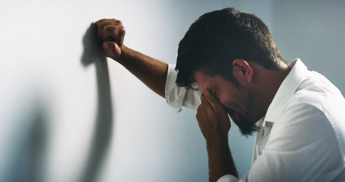 Depression, stress and business man crying for fail, financial crisis or mistake by wall in office. Sad, anxiety and unhappy worker with investment loss, bankruptcy and challenge with unemployment