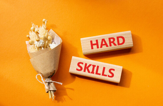 Hard skills symbol. Wooden blocks with words Hard skills. Beautiful orange background with bouquet of flowers. Business and Hard skills concept. Copy space.