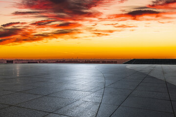 Empty square floor and city skyline with modern buildings under a beautiful and dramatic sunset sky