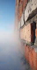 A brick wall corner, angled view, fades into a hazy, white cloud-like atmosphere