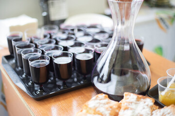 Wine in glasses on a tray. Plastic dishes on the table. A tray of wine.