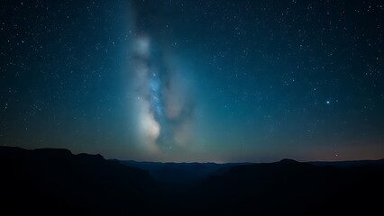 Mountain landscape under a starry night sky with the Milky Way visible, creating a serene natural scene.