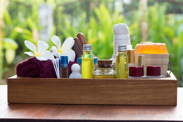 Beauty treatment items for spa procedures in box wooden on table. massage stones, herbal compress, essential oils and soap. spa and massage concept.