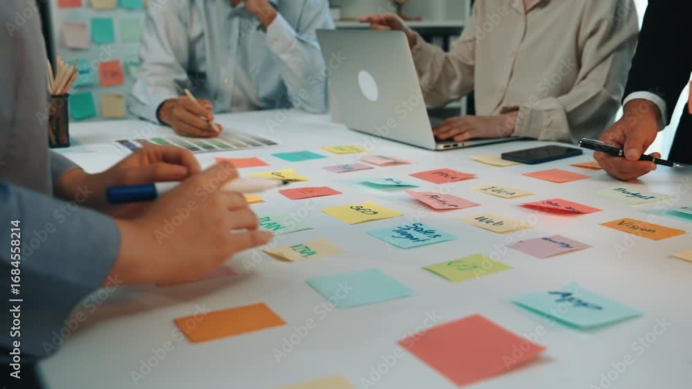 Poster a vibrant office scene showcasing a collaborative brainstorming session with colorful sticky notes o