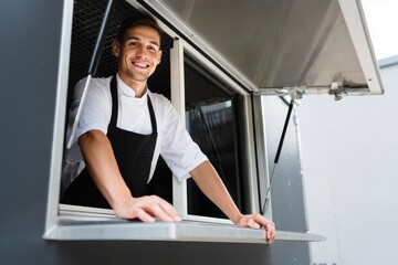 Happy chef in food truck smiling portrait mobile kitchen business owner street food vendor