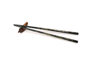 traditional Chinese painted wooden chopsticks resting on a wooden stand, isolated on a clean white background