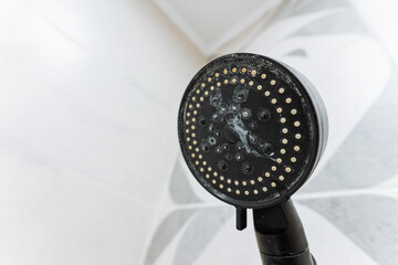 A detailed closeup image showcasing a showerhead that features multiple water spray holes and has...