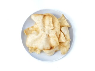 Kerupuk udang or Indonesian traditional snack made from flour and shrimp on plate isolated on white background, Flat lay 