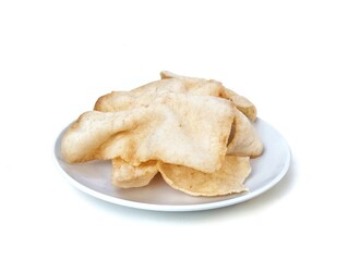Kerupuk udang or Indonesian traditional snack made from flour and shrimp on plate isolated on white background, High angle view 