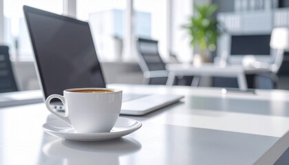 A serene office setting with a laptop, a fresh cup of coffee on a saucer, capturing a sense of modern work and relaxation.