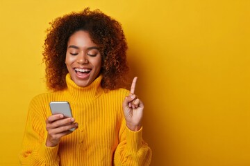 Excited african american woman using smartphone on yellow background having an idea