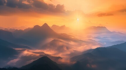 Panoramic view of mountain range at sunrise with mist in valley landscape