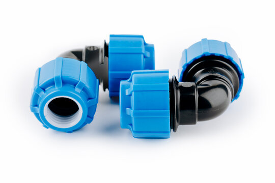 Various plastic fittings for polypropylene pipes on white insulated background.
