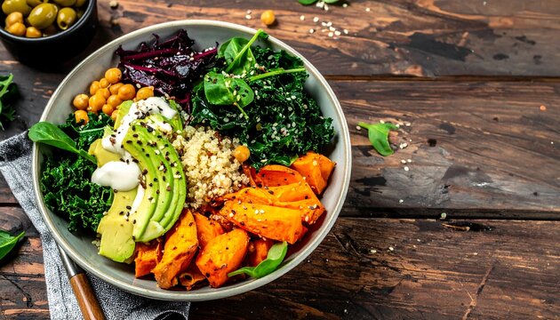 Colorful healthy bowl with quinoa, kale, sweet potato, avocado, chickpeas, and more