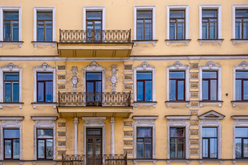 The wall of an old stone building with balconies.