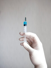 Doctor hand in white glove hold syringe with preparation jet from the needle. Medical man holding injector with drugs in arm. Surgeon with flu intravenous vaccine. Botox injection syringe therapy.